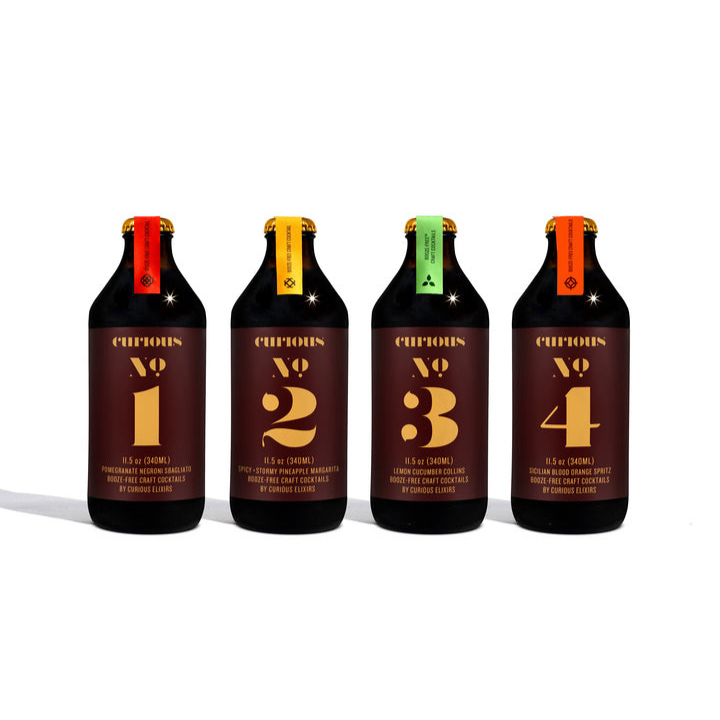 Four bottles labeled Curious No. 1 to No. 4 arranged side by side with different colored caps and branding on the labels.